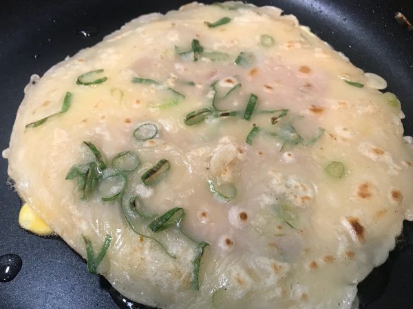 放上剛剛煎好的蛋餅皮，以鍋鏟稍作按壓，
使蛋液沾上蛋餅皮，並待蛋面煎熟即可取出。