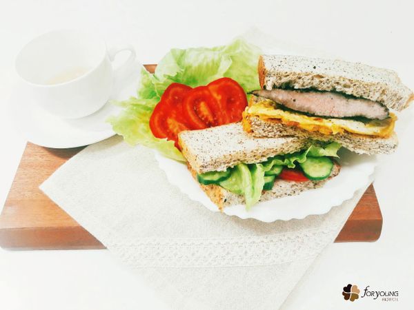 取吐司放在盤子上，依序放入食材，再對半切即可。