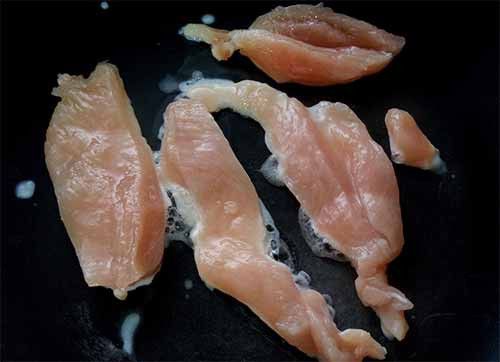 將醃好的雞胸肉放入鍋中，蓋上鍋蓋以小火悶煎至表面泛白
