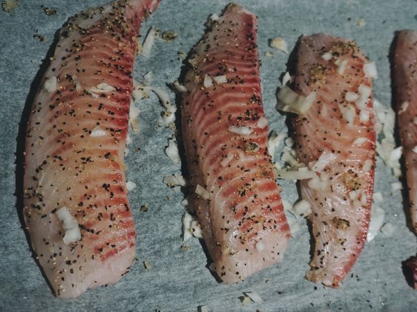 將鹽、黑胡椒、蒜末、洋蔥丁抹勻在鯛魚片上