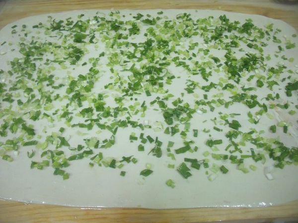 桌上抹上油,取一個劑子擀成長方形,剛開始較不好擀開,慢慢擀,大約1~2分鐘就擀好了,抹上豬油,撒上胡椒粉,蔥花。