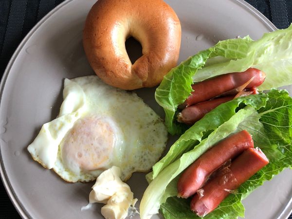 裝盤囉，將美生菜洗乾淨折兩半，也把德式香腸切兩段，把香腸放在美生菜上面，再放上貝果跟荷包蛋，在放兩小匙高鈣乾酪（配麵包真的好吃）！