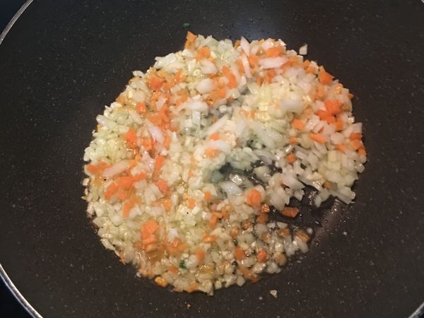 鍋燒熱後，倒入適量橄欖油，炒香洋蔥、蒜末和紅蘿蔔丁；