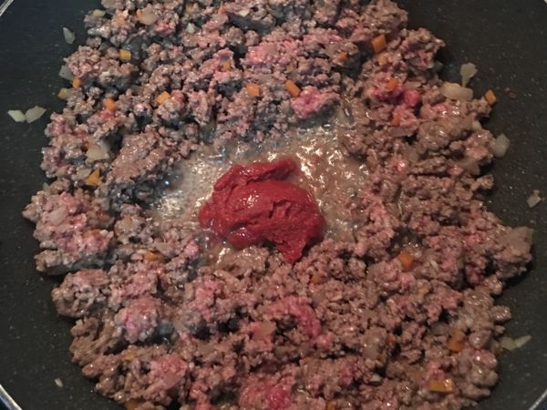 炒到七成熟後，放入蕃茄糊和蕃茄醬拌炒；