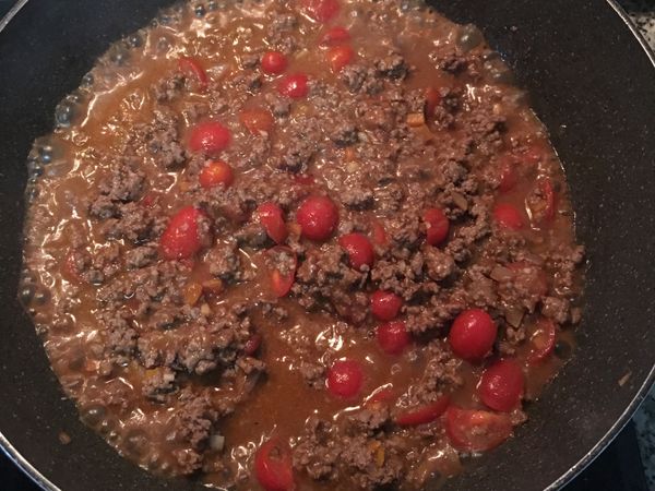 倒入酒和水約淹到牛肉邊緣即可，中小火煮滾；並加入糖拌勻；