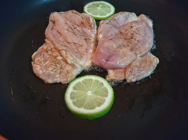 熱鍋薄油中大火煎1分半(勿動)。
切好的檸檬薄片也下去煸。