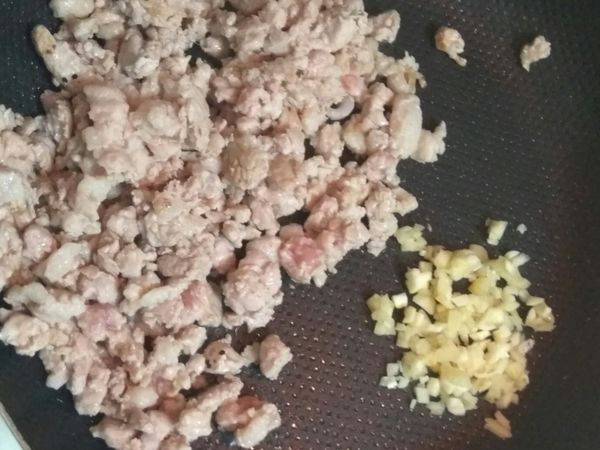 先放入絞肉，稍微煸出油後再加入蒜頭爆香
