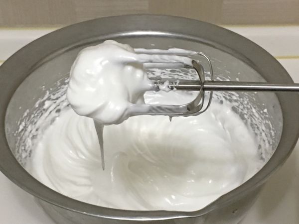 取一鋼盆，將蛋白與細砂糖分3次加入，以電動打蛋器打至乾性發泡。