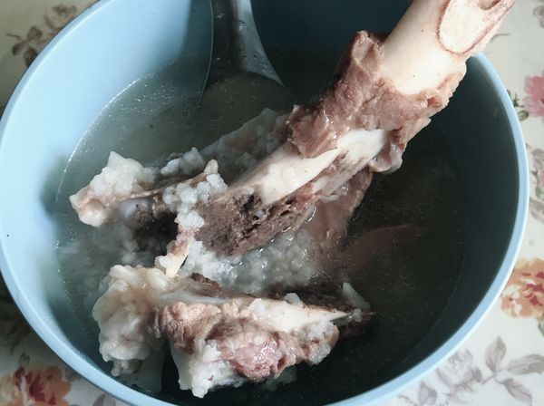 將豬大骨洗淨瀝乾，另煮鍋熱水把血水去掉
豬大骨要先用電鍋煮豬大骨才會軟爛，外鍋放2杯水/內鍋的水一定要蓋過豬大骨，喜歡吃稀一點的粥水就可多放，先把大骨熬出精華在橋上來瓦斯爐煮生米，熬到自己想要的口感就可以關火