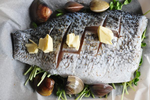 在放上魚片、蛤蜊及奶油，淋上白酒。