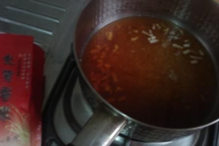 將醃料的醬汁煮滾後加入花枝腳丁，及洗過的大賀米香米放涼並泡1個半小時