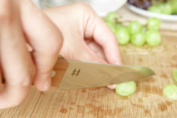 將葡萄對半切開，從外圍開始裝飾蛋糕