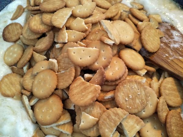 4.鍋子熄火後，加入奇福餅乾（可撥碎，也可不撥），先大致拌勻，再加入一半的櫻花蝦+香鬆+鹽巴，再仔細拌均勻。