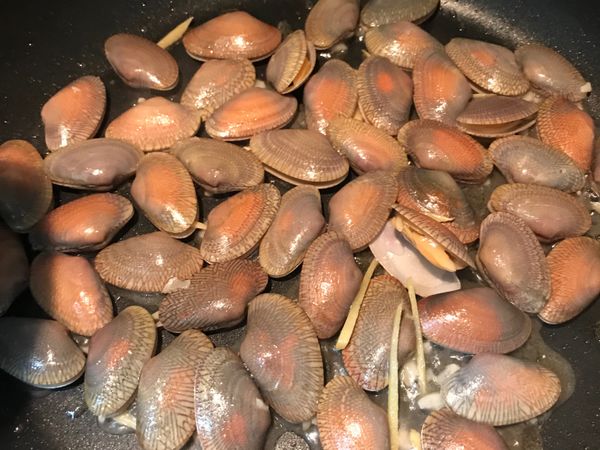 熱鍋後，放沙拉油，麻油，再下薑、蒜爆香（若想吃辣，可在此時加入辣椒）再拿出泡在水中的海瓜子放入鍋內快炒。
蓋鍋可讓海瓜子快開。