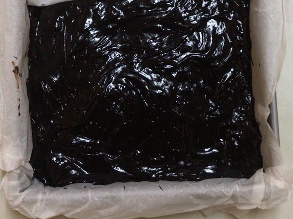 將烘焙紙鋪在方形模具上 將混合好的巧克力倒入模具裡 表面整合好後 拿到冰箱冷凍至少3小時