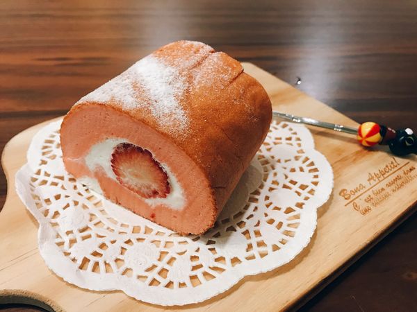 鮮奶油塗上之後放入草莓🍓，用桿麵棍協助捲起之後放冰箱3小時以上，之後就可以享用喔！
取出可以適量撒上糖粉裝飾！
上圖是半捲！