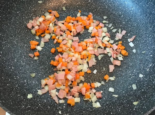 鍋內倒油先炒火腿，待火腿香氣散出後，開始炒洋蔥
等洋蔥稍微呈現透明狀，將先前備用的紅蘿蔔也放入鍋中入炒