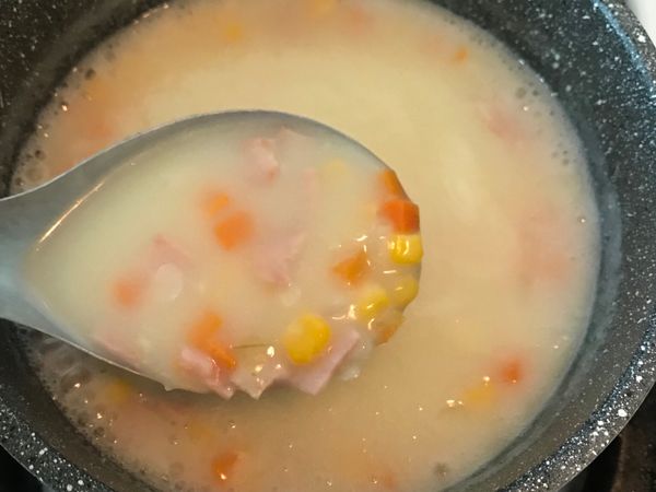 扣掉炒麵糊使用的水，將剩下的水量和先前炒好的洋蔥、蘿蔔、火腿與玉米丟入炒好的麵糊中，以中小火慢慢煮到滾