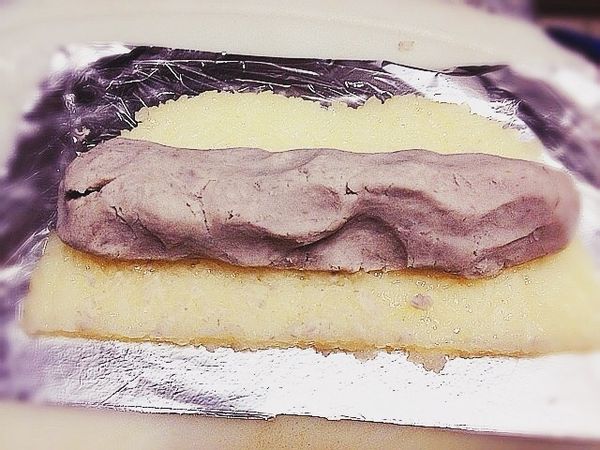 移除糯米飯上保鮮膜，取芋頭泥捏成長條狀，再利用鋁箔紙將糯米飯包覆芋頭泥慢慢捲成長條狀