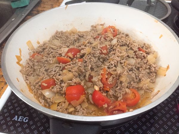 加入絞肉拌炒，可先加點黑胡椒一起拌。絞肉變色後加入小番茄，拌炒至出水。

水稍微收乾一點後，轉小火。