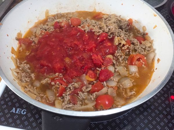 倒入番茄罐頭和一些水（蓋過食材即可），拌勻後小火等水滾，再加入番茄醬、鹽、糖、黑胡椒、辣椒粉等調味料調整口味。