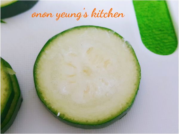 把櫛瓜切片，每片切成差不多的厚度，兩面並沾上太白粉。