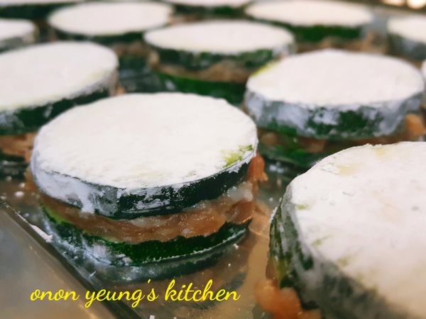 再鋪上另外一片兩面已沾滿太白粉的櫛瓜，然後，輕輕的往下壓一下。