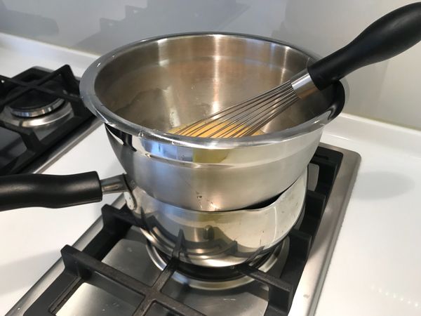 將水用大火加熱煮滾後，轉成小火。將盆子放上爐子，時時攪拌蛋液，確保蛋液均勻熟化至綿密。