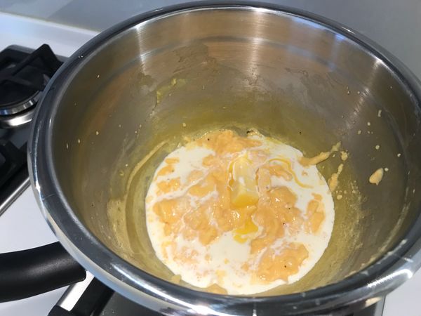 蛋液熟化後，將鮮奶油和奶油加入鍋中，攪拌均勻，即完成。