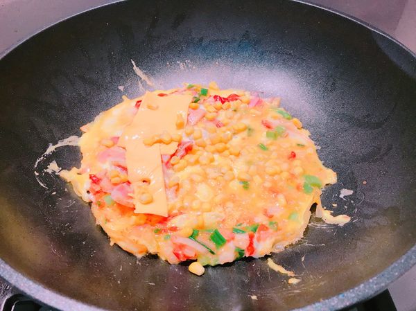 放入蔥、玉米粒、培根、蛋液。
轉小火。