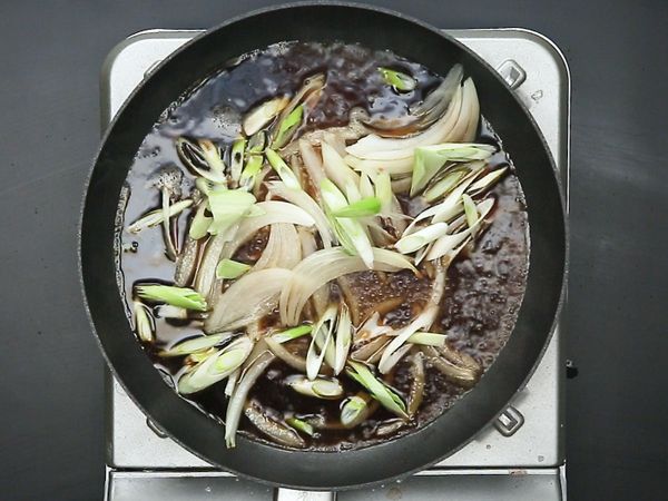 延續使用雞肉逼出的油，依序加入高湯、醬油、味霖、洋蔥、蔥白、雞肉，燉煮至雞肉熟透。