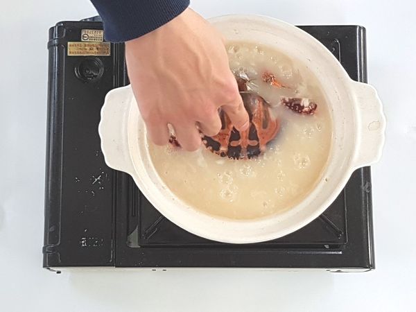 蓋上鍋蓋先以大煮至沸後，再調小火熬煮約30分鐘至黏稠(中間需時常翻蓋攪拌與補水)。
接著將花蟹、鮮蝦和墨魚加進粥裡以小火燜約8分鐘。