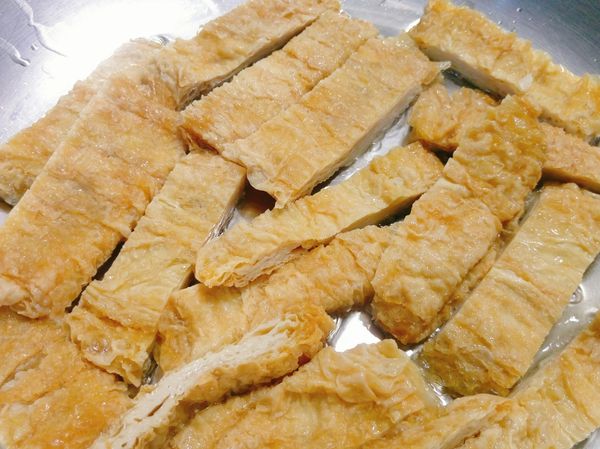 如果是使用生豆皮，先用滾水燙過，再用紙巾擦乾，切條狀，熱鍋下油煎; 如果是使用炸過的豆皮，可直接切條下鍋煎，油量太少或鍋不夠熱易黏鍋。
