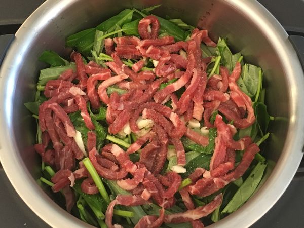 將空心菜、牛肉絲、蒜頭全部放入鍋中，並淋上橄欖油，撒上適量鹽巴