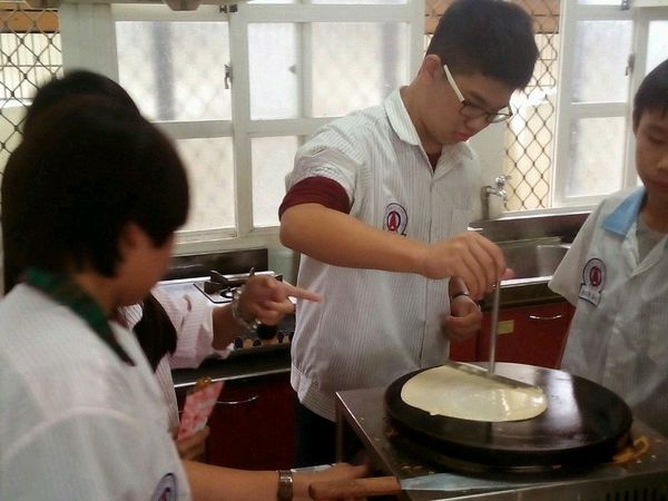 用T字棒將麵糊先由上往下拉，將麵糊攤開，然後再依順手方向攤開。