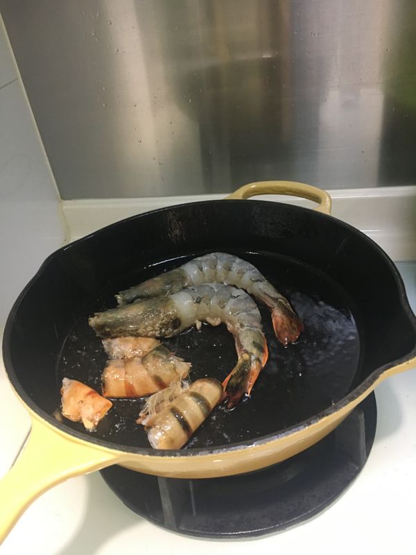3. 燒紅鑊，中大火，下橄欖油(油要下多一點)及無鹽牛油放入大蝦及蝦殼，將大蝦煎至8成熟，盛起大蝦；轉大火，將蝦殼煎至金黄，盛起。