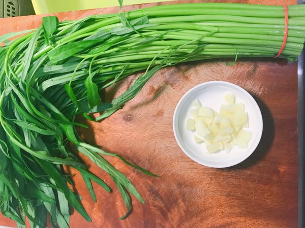 將蒜頭去尾剝皮切碎（也可切片），空心菜去根）。