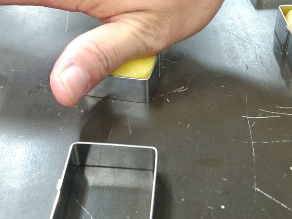 用手掌肉多的地方將橢圓形壓入模具內。