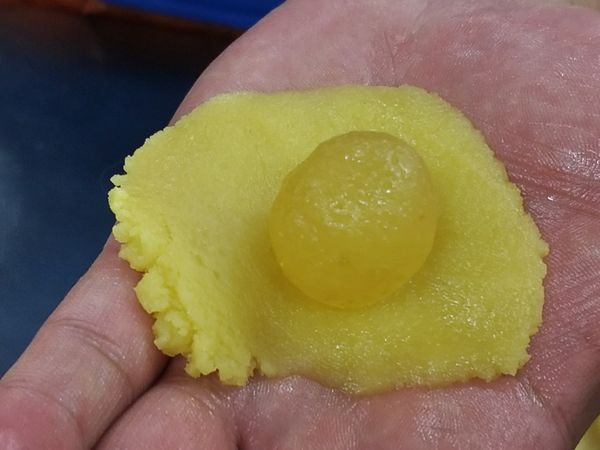 將鳳梨膏包入麵團內，搓成橢圓型，放入模具中。