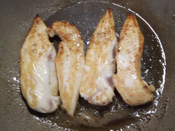 以中小火慢煎至半熟後，
加入蒜片慢慢爆香，

雞柳兩面約8分熟時，轉至中火，灑入適量的鹽，胡椒粉，香草粉。