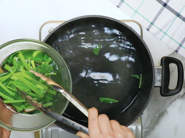 菠菜洗淨後切段，熱水鍋中倒入鹽，將波菜下鍋川燙，取出放入冷水中備用。
