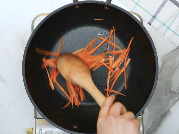 鍋清乾淨後，下油，將紅蘿蔔絲、洋蔥絲、小黃瓜絲、醃過的豬肉絲分別拌炒調味，取出備用。