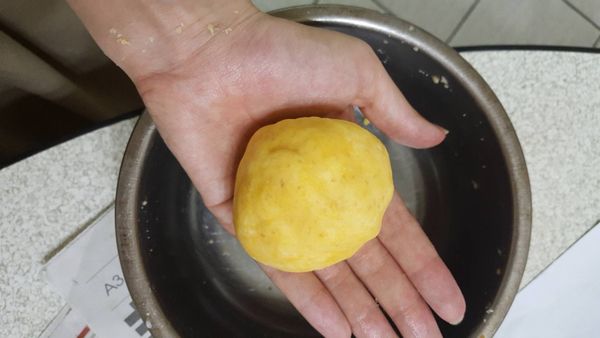 加入蛋黃及澱粉，並用抹刀攪拌，可用手輔助