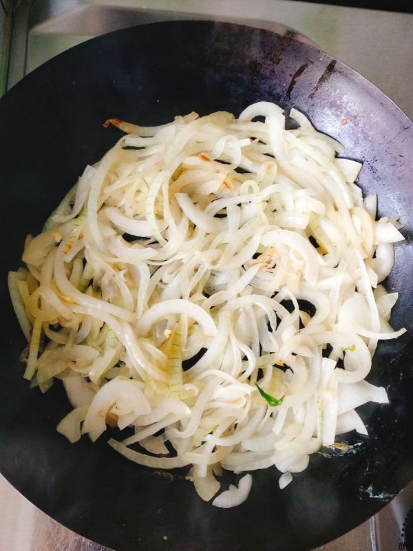 鍋子再度加熱，放入少許油，續放入洋蔥絲與鹽巴，炒至洋蔥呈現半透明狀，轉小火。