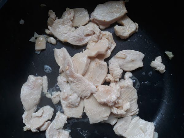 下一點橄欖油，炒蒜末，下雞胸肉片，加少許米酒翻炒，兩面變白盛起備用。