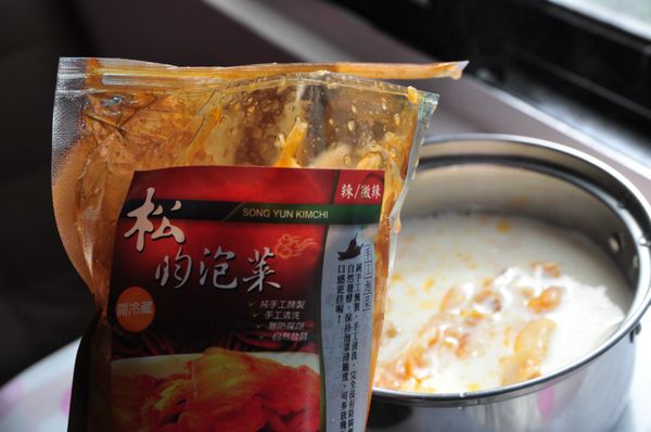 將豆漿煮滾後，轉中小火，放入適量的泡菜及湯汁