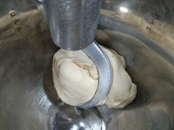 製作煎餃皮1：中筋麵粉、鹽、冷水以鉤型攪拌器慢速拌勻至表皮光滑。