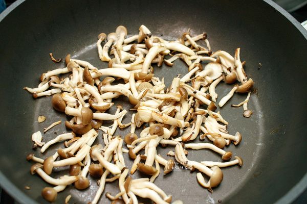 取一平底鍋，將鴻禧菇(去蒂頭後掰散)入鍋，以中小火乾煎至呈金黃色為止。