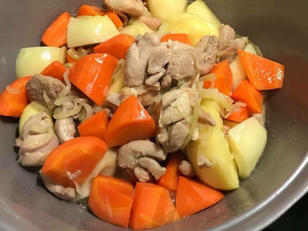 依序加入紅蘿蔔、馬鈴薯、雞肉塊拌炒5分鐘