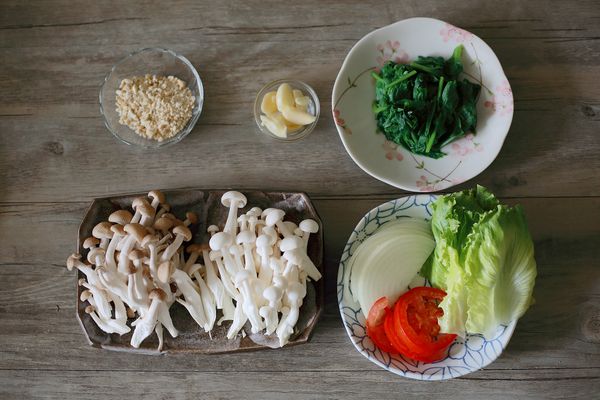 波菜去除粗梗，保留葉片切成小段入滾水川燙撈起瀝乾水份，蒜頭拍扁、堅果敲成小碎塊、洋蔥切絲、牛番茄切片、生菜洗淨瀝乾水份備用。